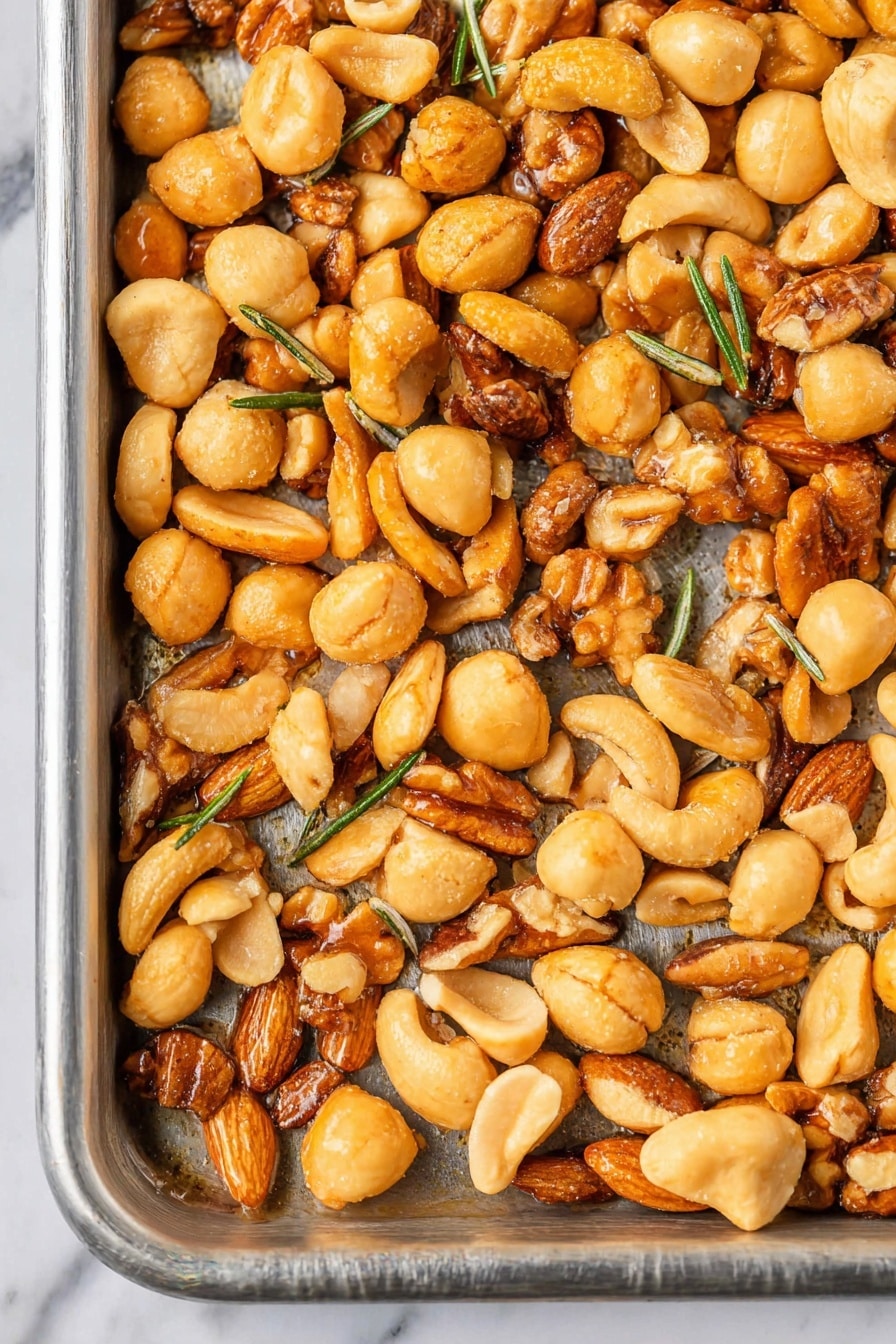Savory Herb-Crusted Nuts, savory nut snack, herb-coated nuts recipe, seasoned nuts with herbs, flavorful nut mix - A close-up view of a round white bowl filled with mixed toasted nuts, mainly light brown macadamia nuts and darker brown walnut pieces, mixed with small green herb leaves scattered throughout. A silver spoon lifts some nuts above the bowl, highlighting the shiny, roasted texture of the nuts. The background shows a white marbled surface partially covered by a white cloth with blue stripes and an amber-colored drink in a clear glass. photo taken with an iphone --ar 2:3 --v 7